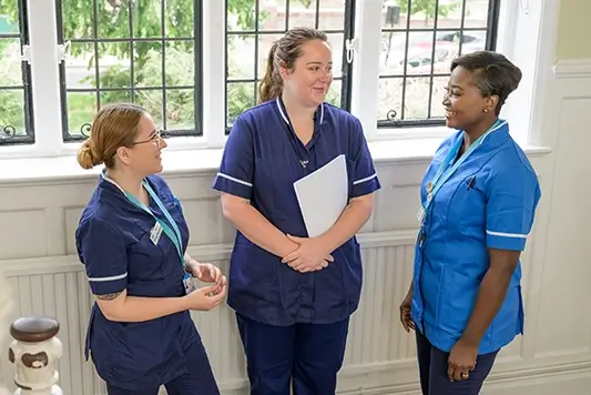 MSI UK nurses talking in hallway.