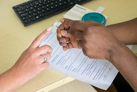 Nurse and client touching contraceptive coil.