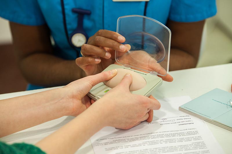 Nurse showing client dummy contraceptive implant