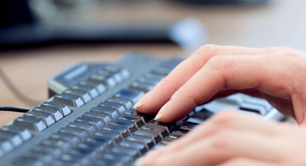 Fingers typing on keyboard.